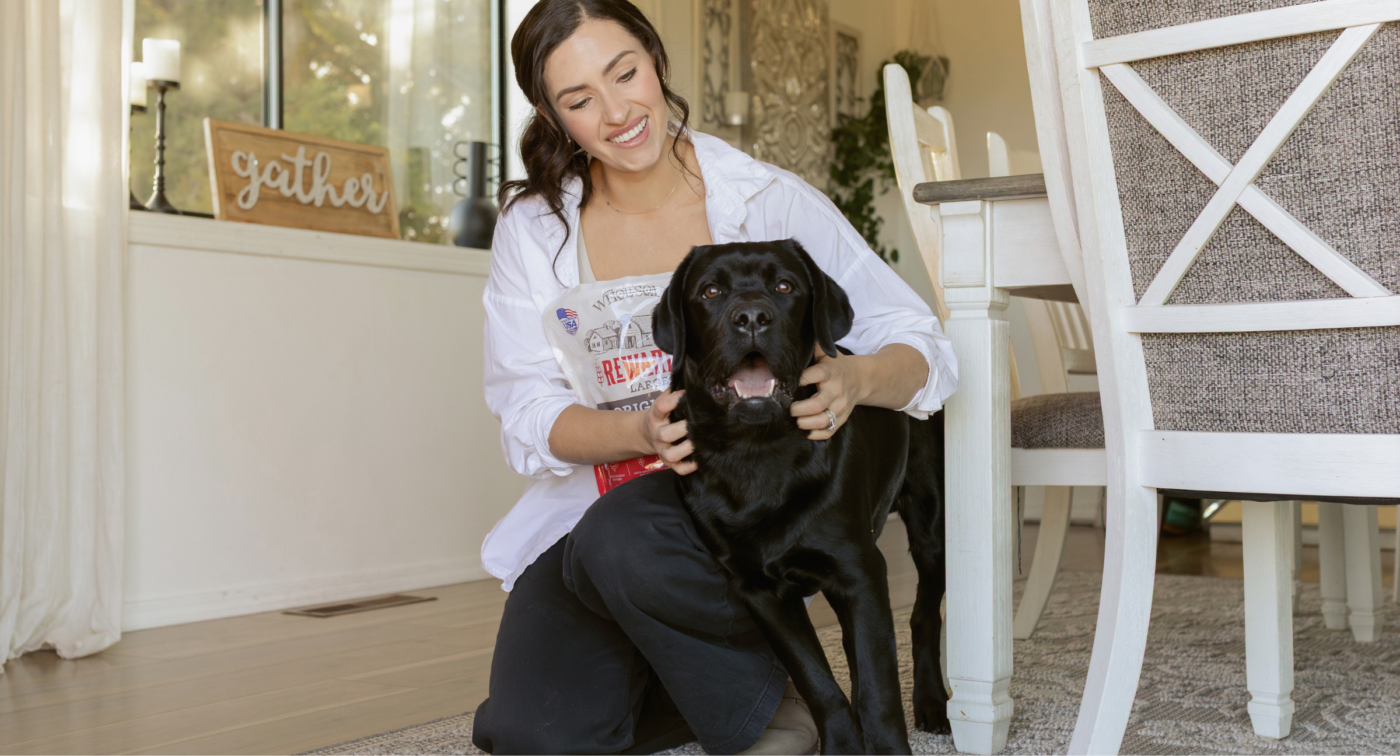 women petting dog with wholesomes original dog treats